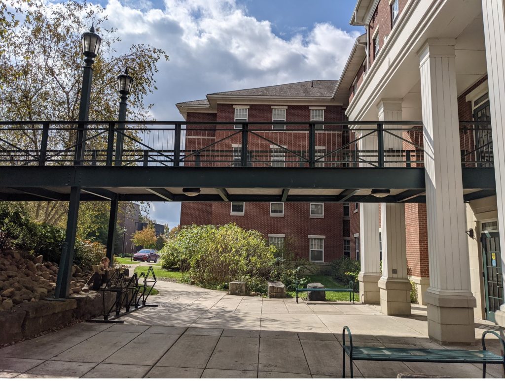 photo of building with bridge coming off of second floor going across rain garden/plaza area, best student housing multifamily apartment architect in Pittsburgh, PA Pennsylvania