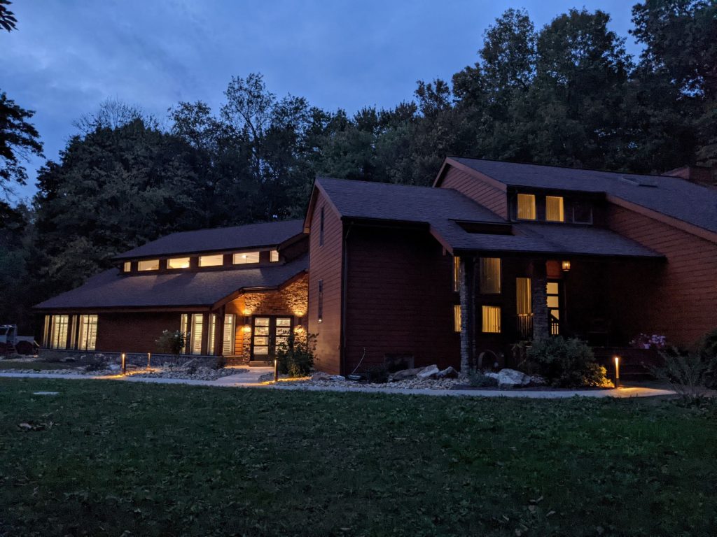 Exterior view of affordable residential contemporary pool house addition to existing home at dusk, beautiful addition, amazing addition, modern residential, indoor pool, affordable renovation, modern design pool