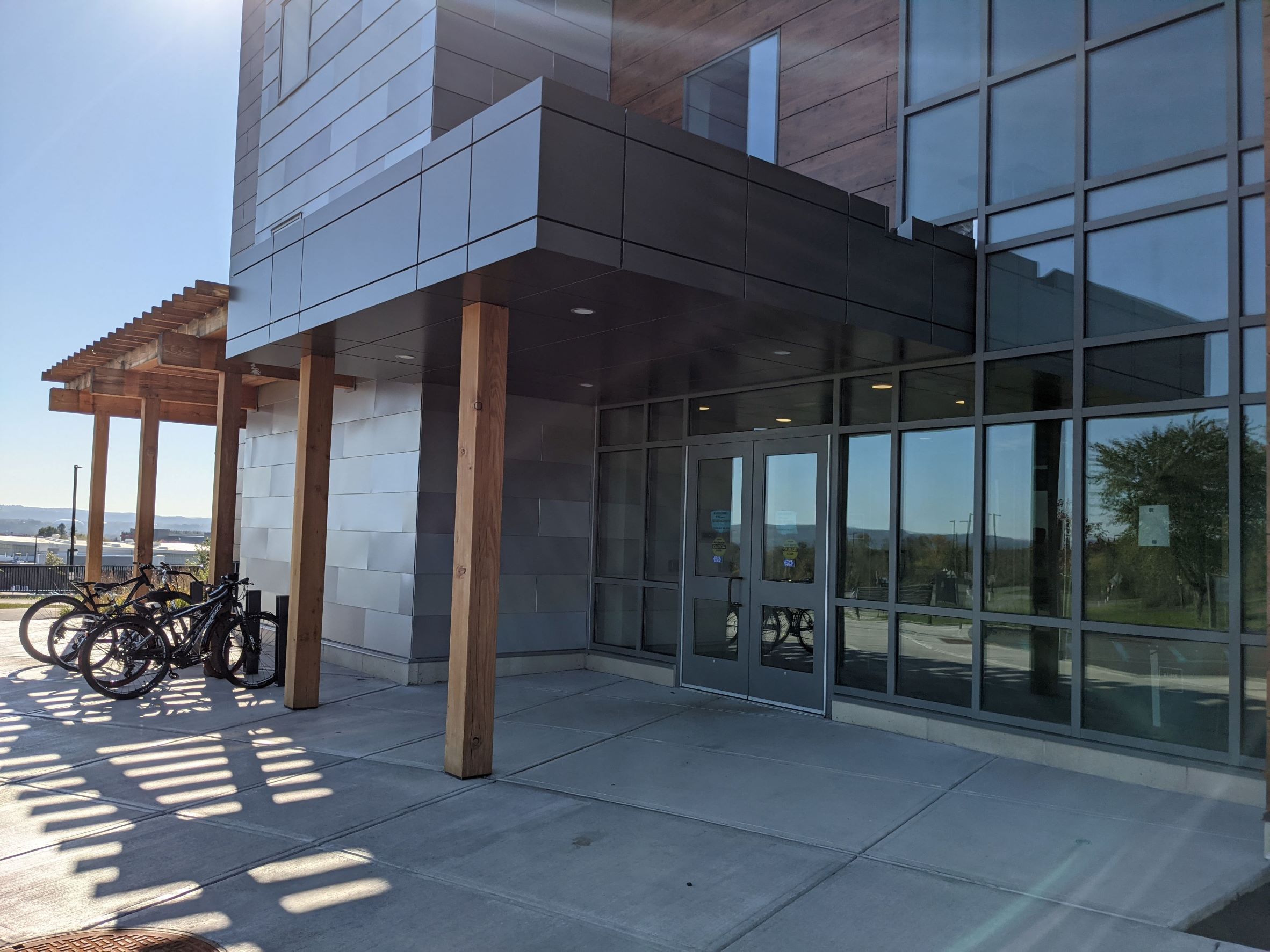 close up of glass building entry with wood panels and metal canopy in Central New York State